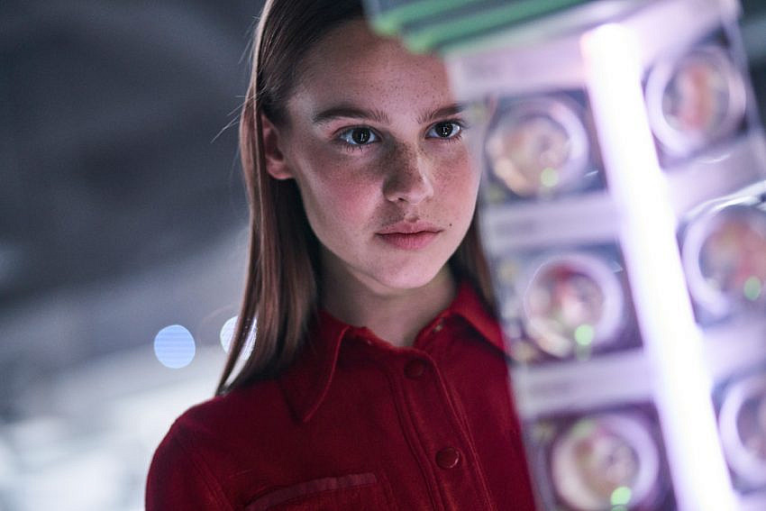 Clara Rugaard as “Daughter” looks at embryos up close in I Am Mother.