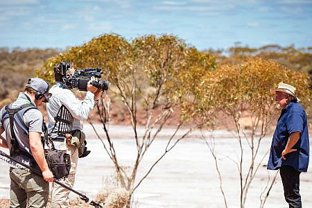 Two crew members with camera and sound equipment filming ‘Dust Devils’ Mike Armstrong in the outback