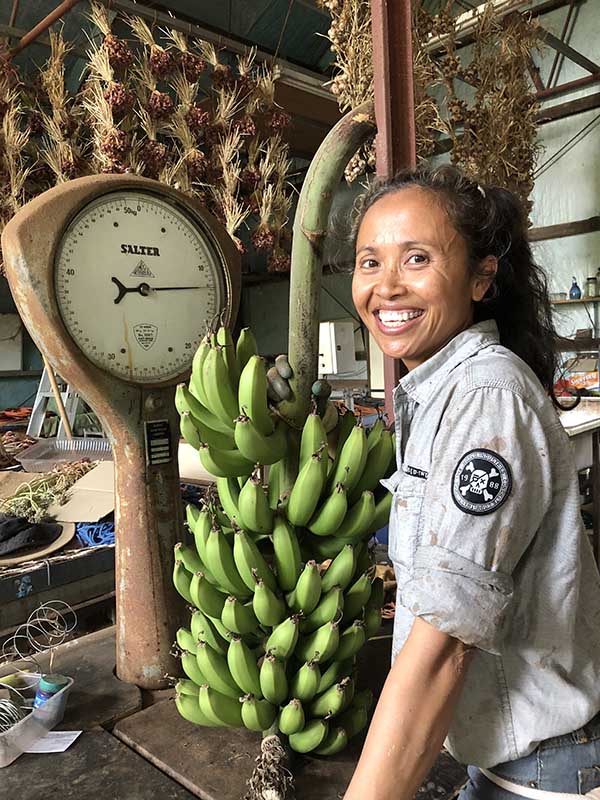 Person standing in front of massive bunch of bananas