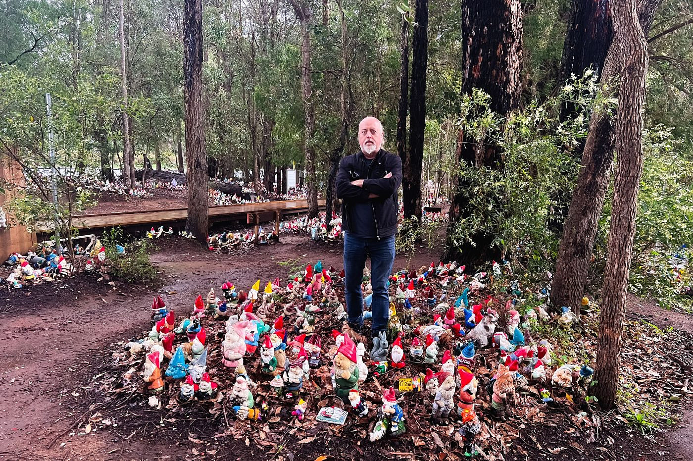 Bill Bailey surrounded by gnomes in Gnomesville, Perth, Western Australia.